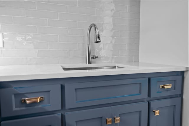 room details featuring light countertops, a sink, and blue cabinetry