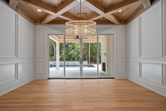 spare room with light wood-type flooring, wood ceiling, coffered ceiling, and a decorative wall