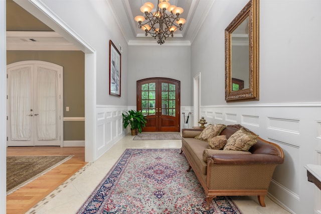 1320 Dejarnet Pl, Greensboro, GA 30642 - tiled foyer entrance with french doors, a chandelier, crown molding, and wainscoting