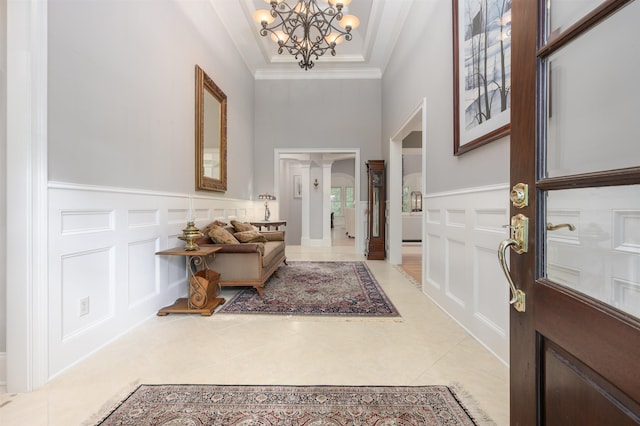 1320 Dejarnet Pl, Greensboro, GA 30642 - entryway featuring a decorative wall, a chandelier, light tile patterned flooring, crown molding, and a high ceiling