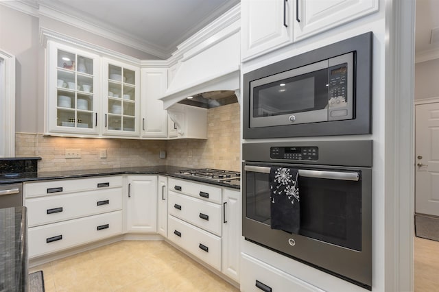 1320 Dejarnet Pl, Greensboro, GA 30642 - kitchen featuring appliances with stainless steel finishes, ornamental molding, white cabinetry, dark stone countertops, and backsplash
