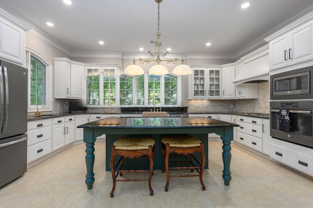 1320 Dejarnet Pl, Greensboro, GA 30642 - kitchen featuring appliances with stainless steel finishes, white cabinetry, a breakfast bar area, recessed lighting, and ornamental molding