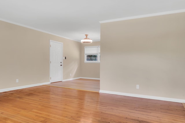 empty room featuring light hardwood / wood-style flooring and ornamental molding