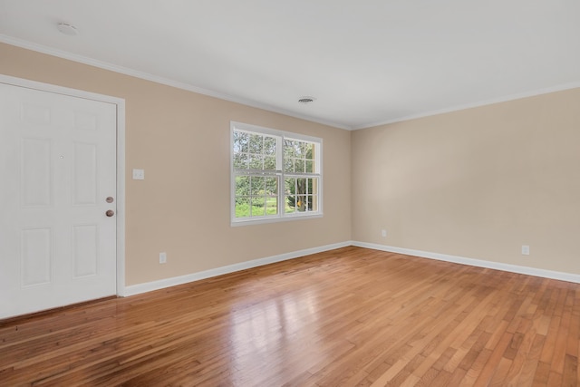 empty room featuring crown molding and light hardwood / wood-style flooring