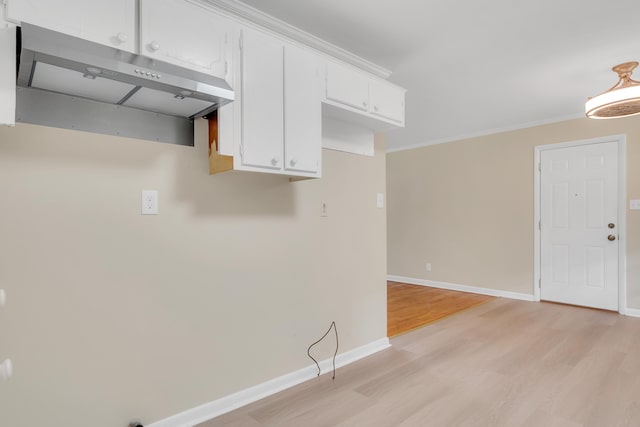 kitchen with white cabinetry, ornamental molding, and light hardwood / wood-style flooring