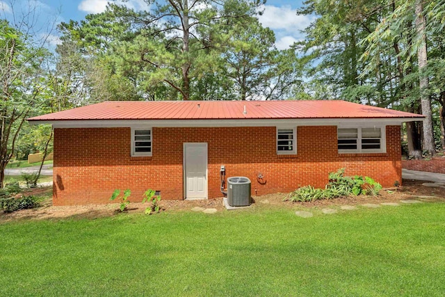 back of house with cooling unit and a yard