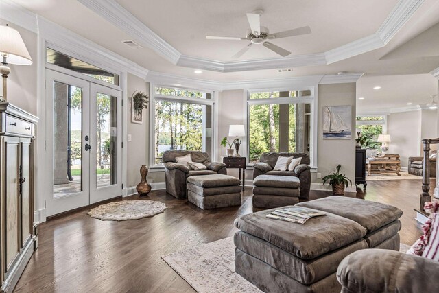 living room with french doors, dark wood-type flooring, crown molding, a raised ceiling, and ceiling fan