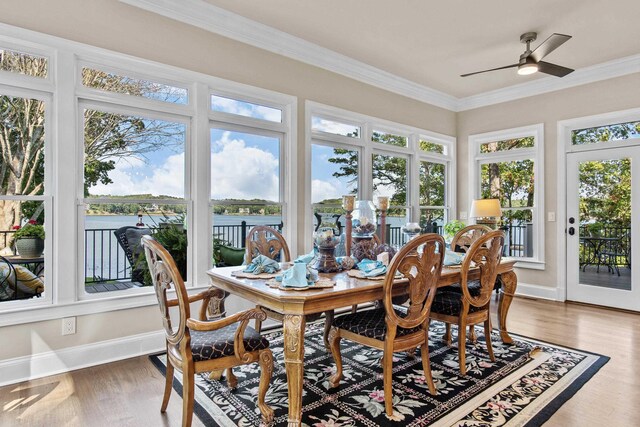 sunroom / solarium featuring a water view, ceiling fan, and plenty of natural light