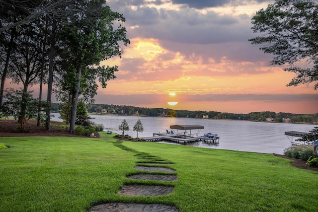 view of dock with a water view and a yard