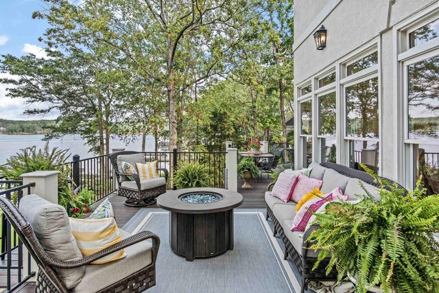 view of patio featuring a water view and an outdoor living space with a fire pit