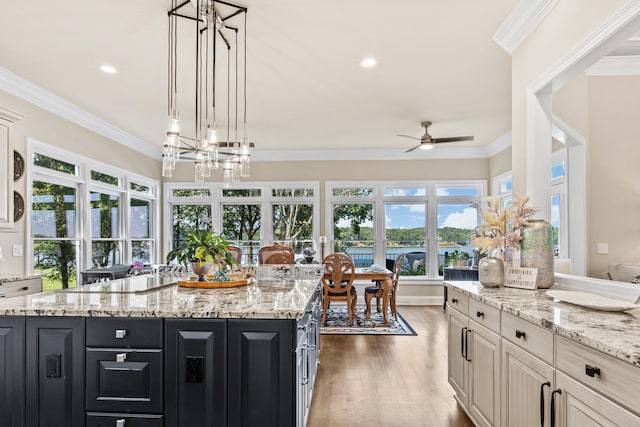 kitchen featuring black electric cooktop, crown molding, hanging light fixtures, and a kitchen island