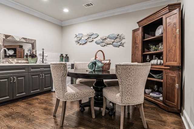 dining space with crown molding, dark hardwood / wood-style flooring, and sink