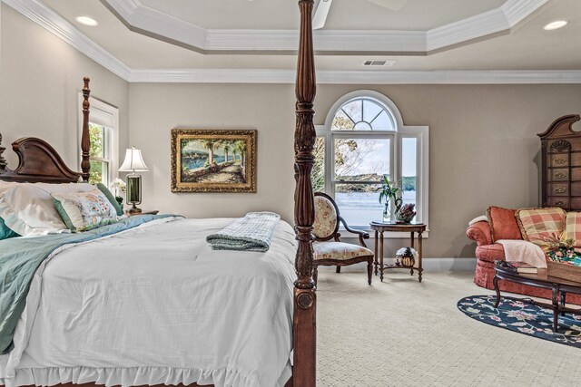 carpeted bedroom featuring a tray ceiling and ornamental molding