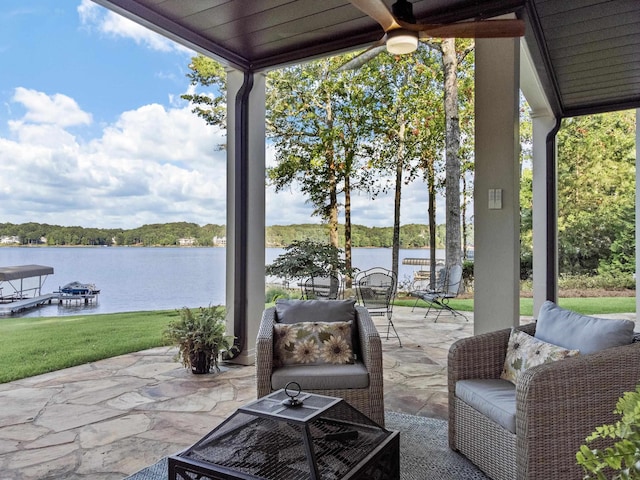 view of patio with a water view and ceiling fan