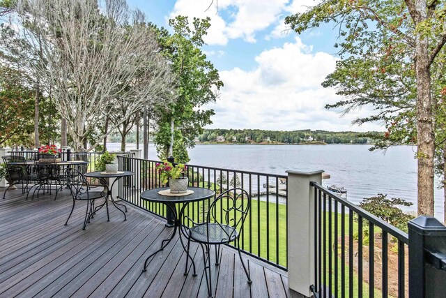 deck with a lawn and a water view