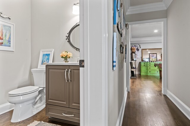 bathroom with vanity, hardwood / wood-style floors, crown molding, and toilet