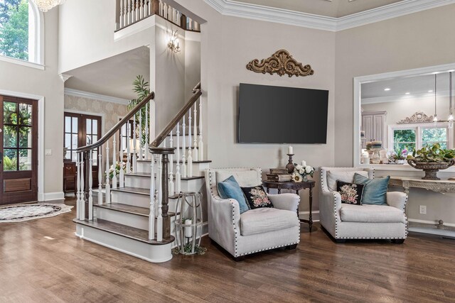 interior space featuring wood-type flooring, ornamental molding, french doors, and a high ceiling