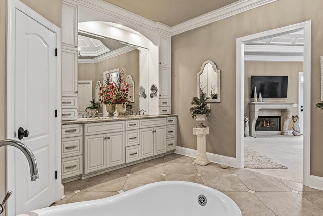 bathroom featuring crown molding, a tub to relax in, tile patterned flooring, vanity, and a premium fireplace