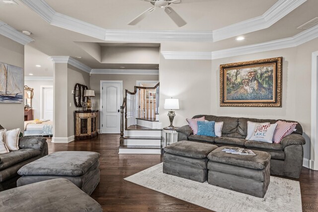 living room featuring a raised ceiling, ornamental molding, dark hardwood / wood-style floors, and ceiling fan