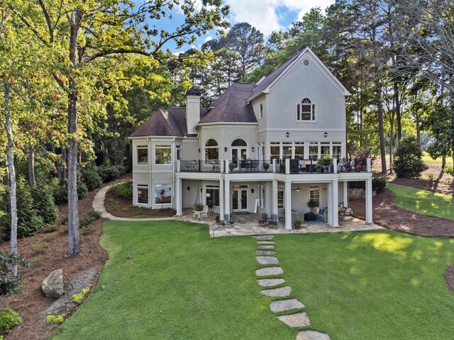 back of property featuring a patio, a deck, and a lawn