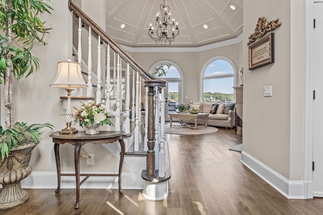 entrance foyer featuring dark wood-type flooring, crown molding, and a notable chandelier