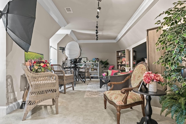 sitting room with track lighting, ornamental molding, and light carpet