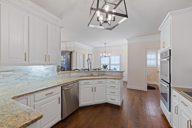 kitchen with stainless steel appliances, a sink, a notable chandelier, a peninsula, and dark wood-type flooring