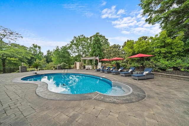 outdoor pool featuring a diving board and a patio area