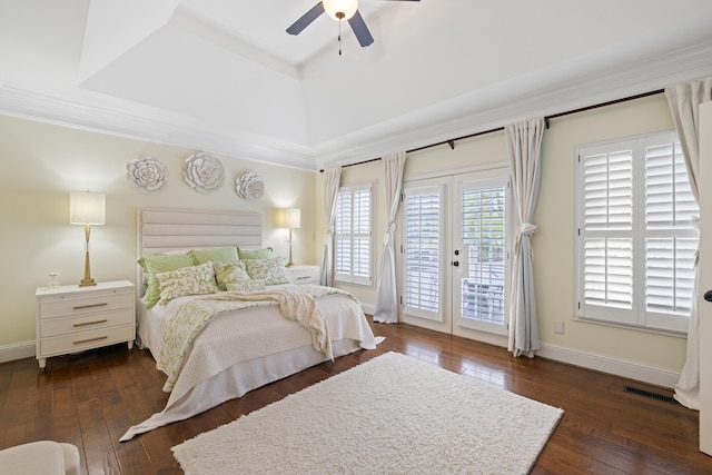 bedroom featuring dark wood-style flooring, access to outside, a raised ceiling, a ceiling fan, and visible vents