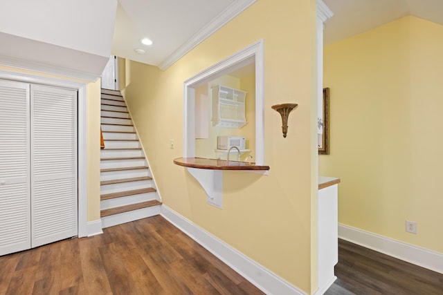 stairway with wood finished floors, recessed lighting, ornamental molding, and baseboards