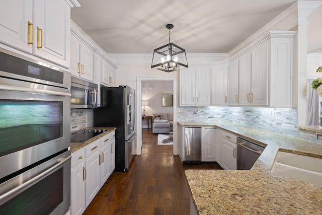 kitchen featuring light stone counters, white cabinetry, stainless steel appliances, and a notable chandelier