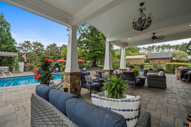 view of patio / terrace with fence, an outdoor pool, a ceiling fan, and outdoor lounge area