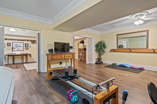 workout area with ornamental molding, ceiling fan, and wood finished floors