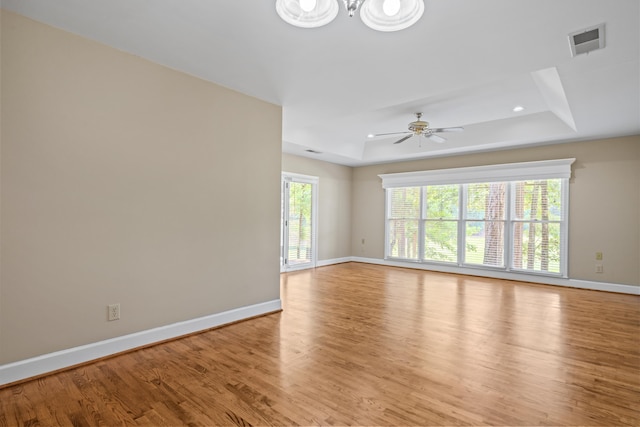 interior space featuring ceiling fan, a raised ceiling, and light hardwood / wood-style floors