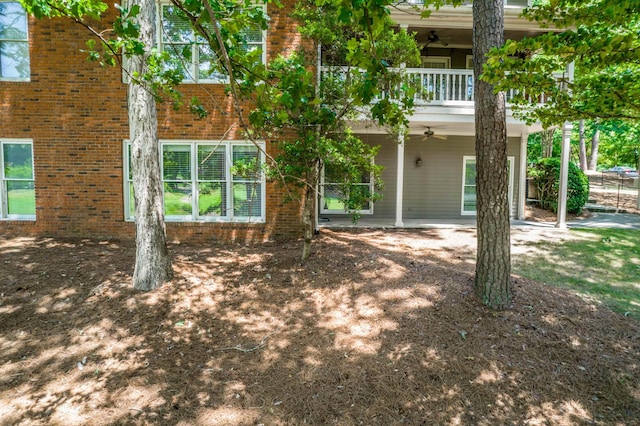 back of property with ceiling fan, a balcony, and a patio area