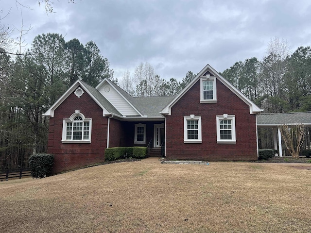 view of front of property with brick siding, a front yard, and fence