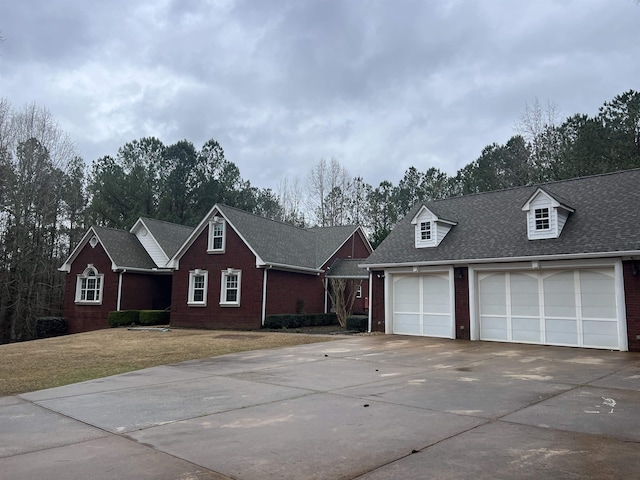 view of front facade featuring brick siding, concrete driveway, a front yard, and roof with shingles