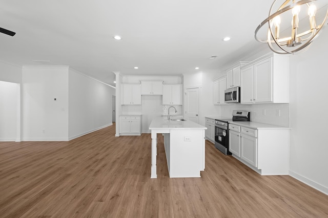 kitchen featuring stainless steel appliances, a sink, light wood-style flooring, and decorative backsplash