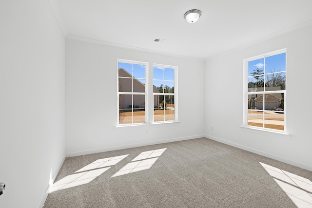 empty room with ornamental molding, carpet flooring, visible vents, and baseboards