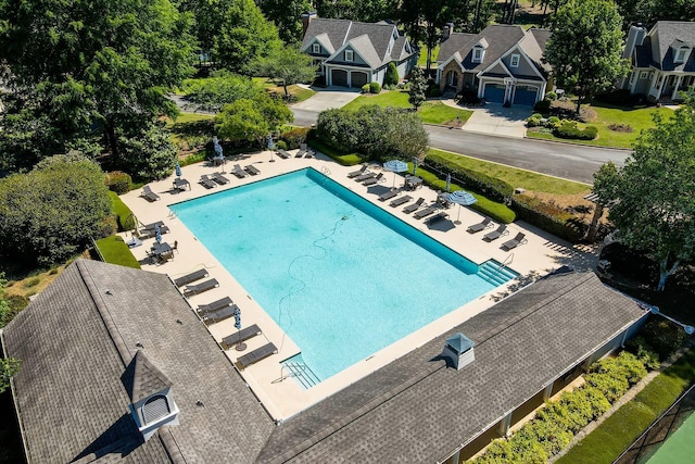 community pool with a patio area and fence