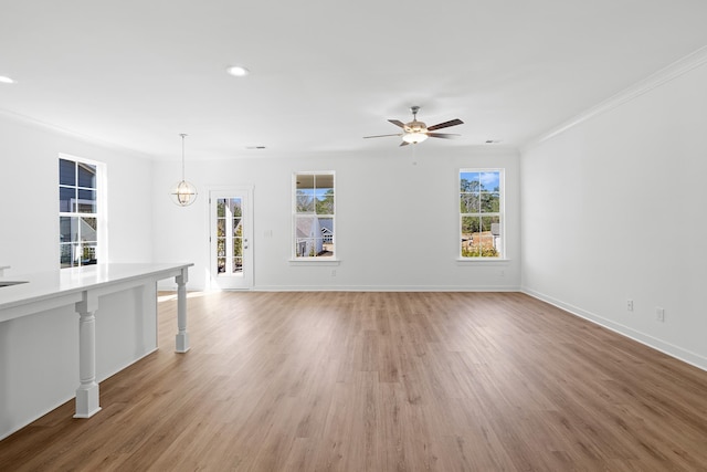 unfurnished room with baseboards, ornamental molding, a ceiling fan, and light wood-style floors