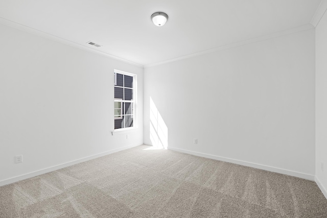 carpeted spare room with baseboards, visible vents, and crown molding