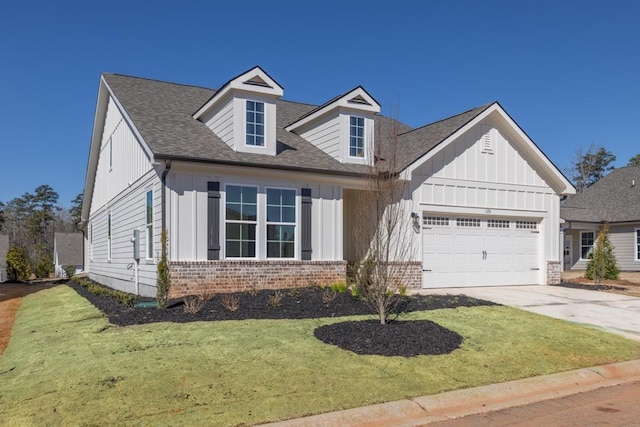 view of front facade featuring an attached garage, brick siding, driveway, board and batten siding, and a front yard