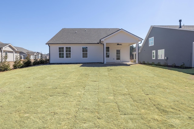 rear view of house featuring a yard, roof with shingles, ceiling fan, and a patio