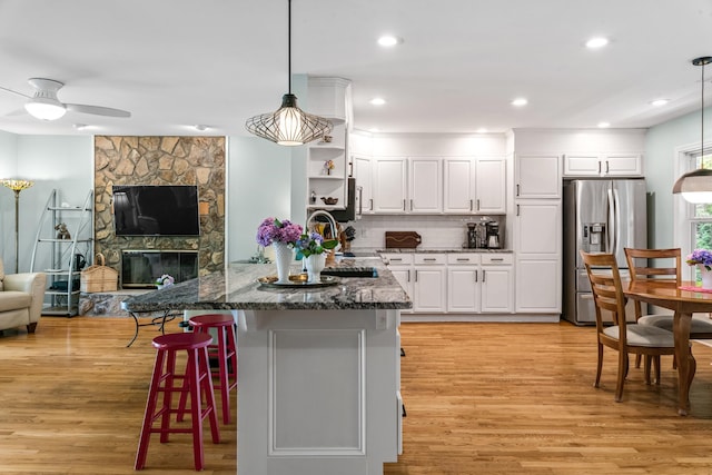 1601 Heidi Trl, Buckhead, GA 30625 - kitchen with stainless steel fridge, a sink, light wood-style flooring, open floor plan, and white cabinetry