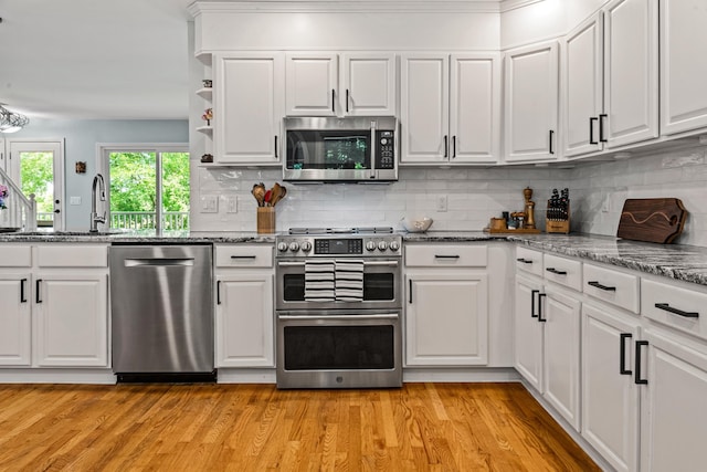 1601 Heidi Trl, Buckhead, GA 30625 - kitchen with stainless steel appliances, white cabinetry, dark stone countertops, light wood-type flooring, and ornamental molding