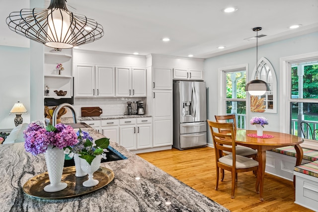 1601 Heidi Trl, Buckhead, GA 30625 - kitchen featuring stainless steel refrigerator with ice dispenser, light stone countertops, light wood-style floors, open shelves, and white cabinetry