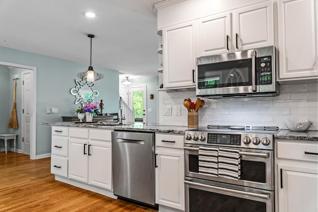 1601 Heidi Trl, Buckhead, GA 30625 - kitchen with appliances with stainless steel finishes, decorative backsplash, white cabinets, light wood-style floors, and dark stone countertops