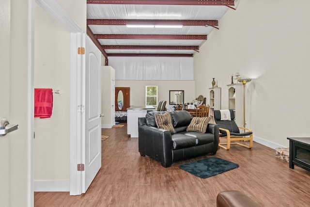 living room featuring beam ceiling and hardwood / wood-style floors