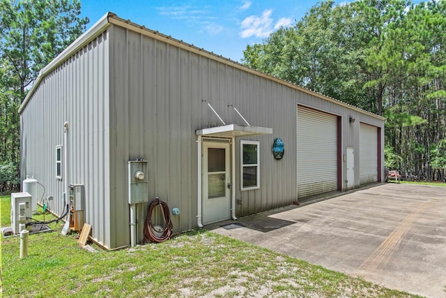 view of outdoor structure featuring a garage and a lawn